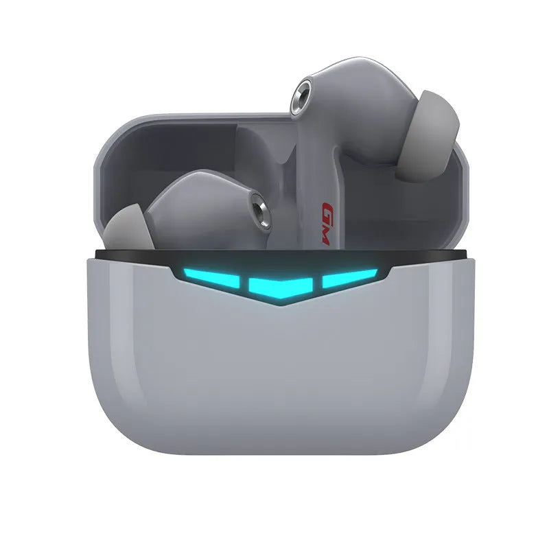Black true wireless gaming earbuds and charging case with three pairs of silicone earmuffs on a grey background.