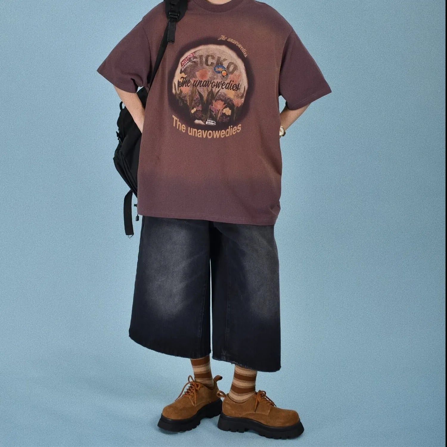 Men's loose straight-leg denim shorts in a light blue wash, showing fifth-pant length and relaxed fit.