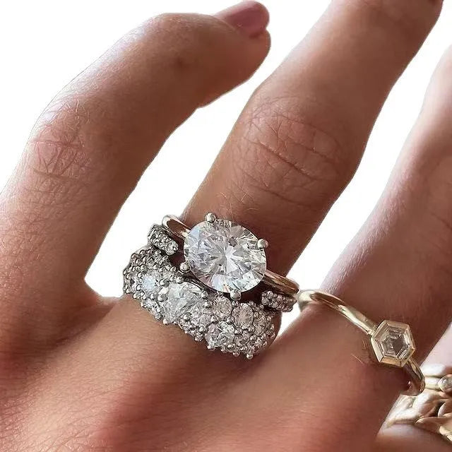 Women's three-piece ring set with mosaic oval zircon stones in white alloy finish on a dark surface