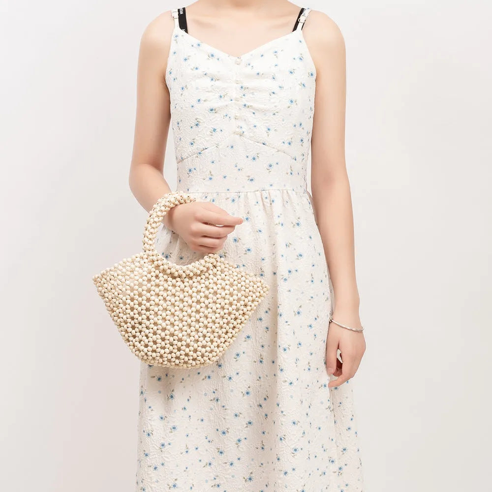Hand-woven dumpling-shaped maple beach handbag with wooden bead decoration in milky white colour