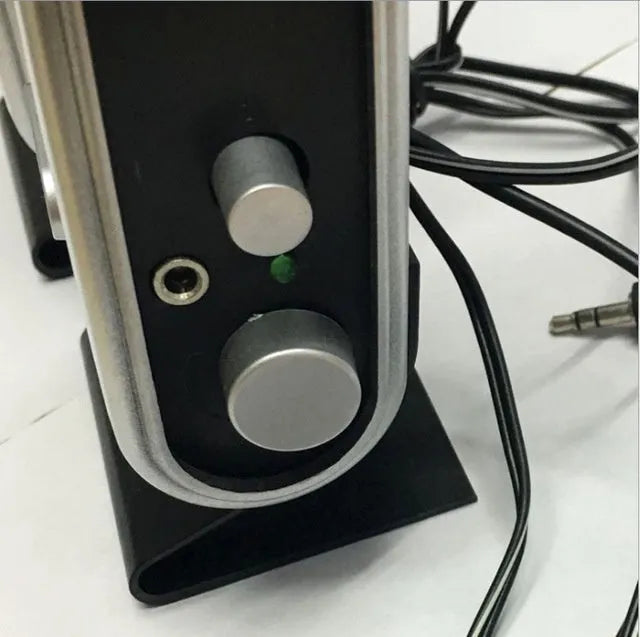 A black notebook mini speaker with a USB cable for computer audio.