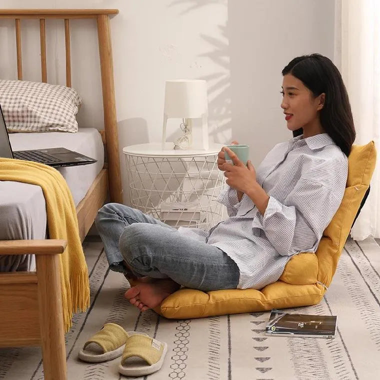 Beige lazy sofa floor chair with adjustable backrest on living room floor showing six-angle mechanism