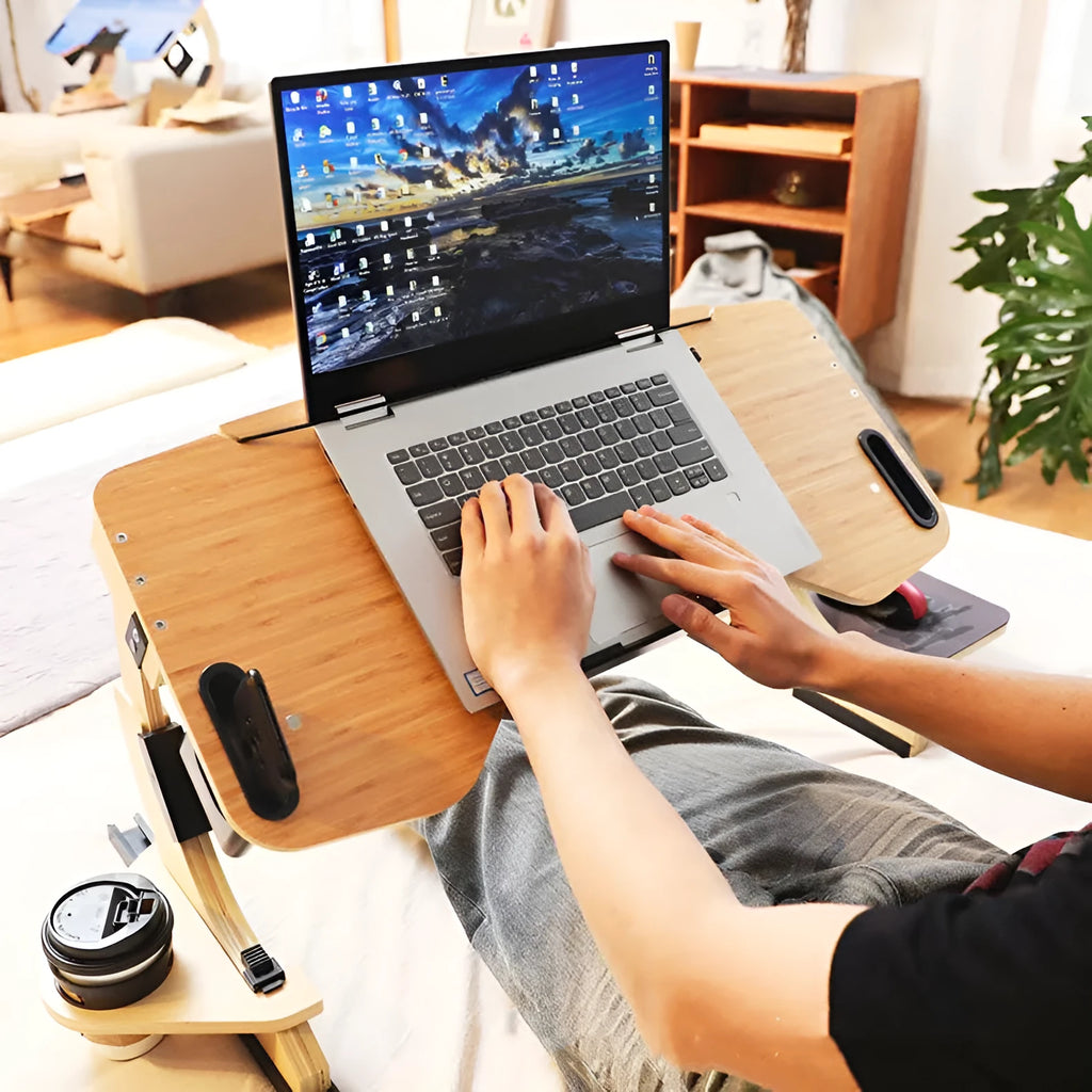 White maple wooden bed table holding a laptop at an angle, folded legs visible on a duvet.