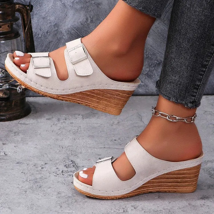 Women's creamy-white beach slippers with a wedge heel and decorative belt buckle on the upper.