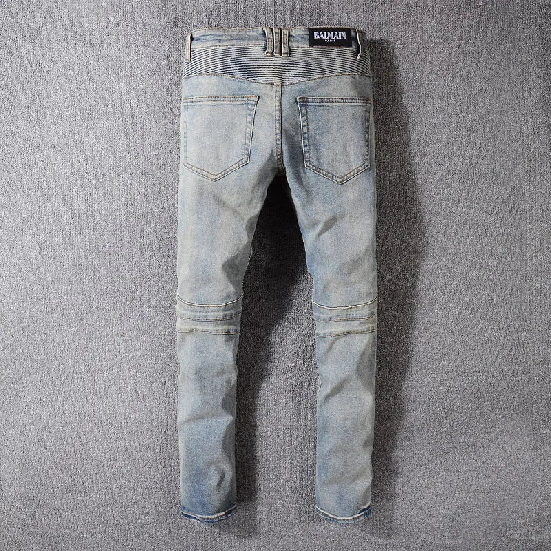 Grey biker jeans with straight tube leg, mid-rise waist, zipper fly, and distressed denim finish