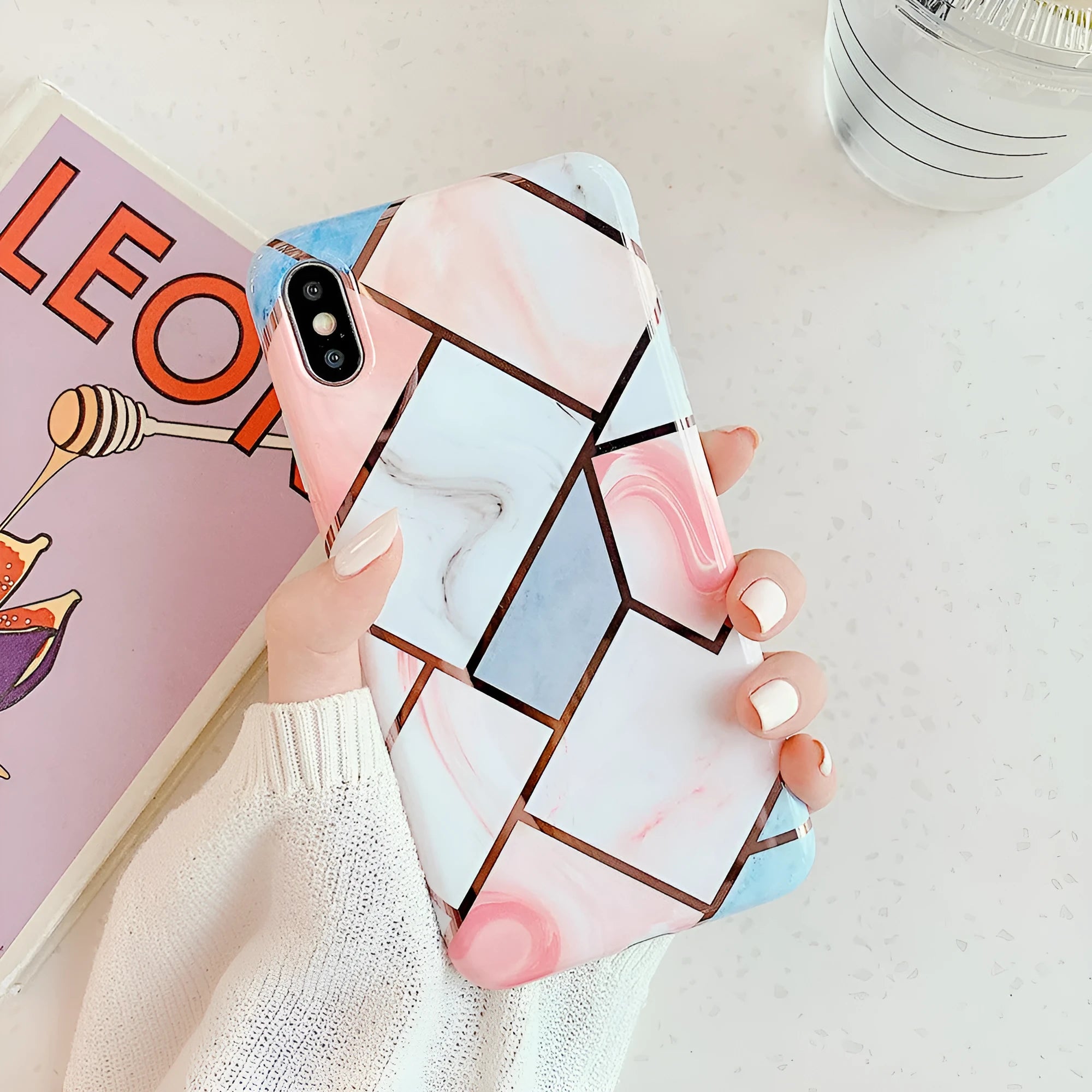 Flexible silicone gel mobile phone case for various iPhone models on a table.