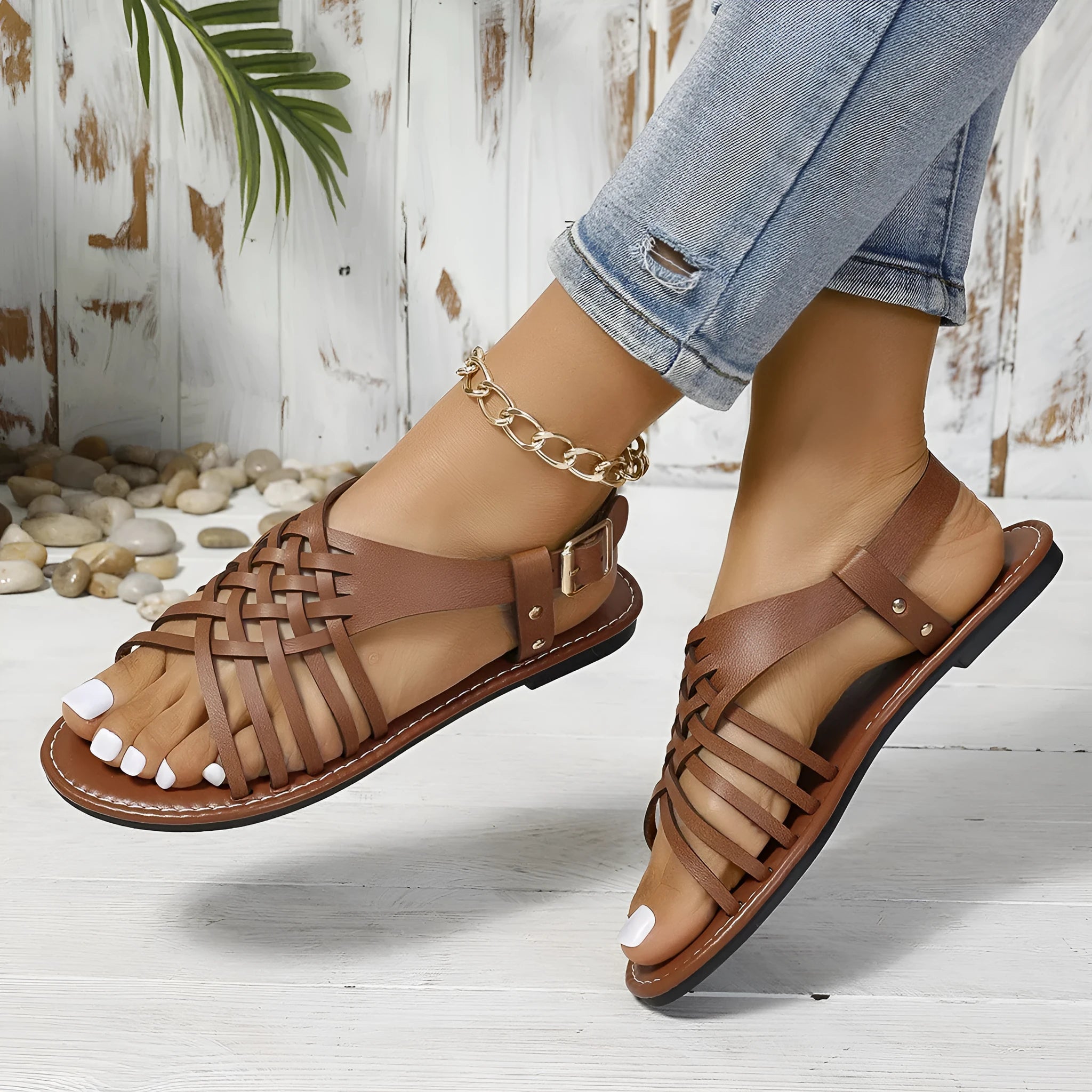 Black Roman style beach slippers with cross straps and a buckle fastening.