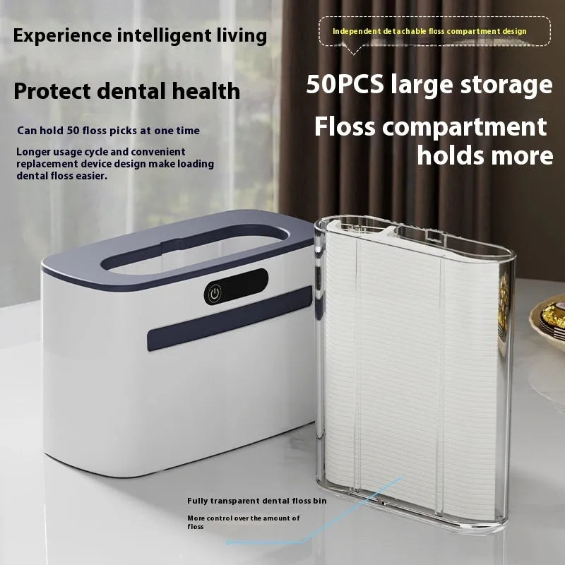 Dark gray automatic dental floss box with USB charging port and pop-up floss dispenser.