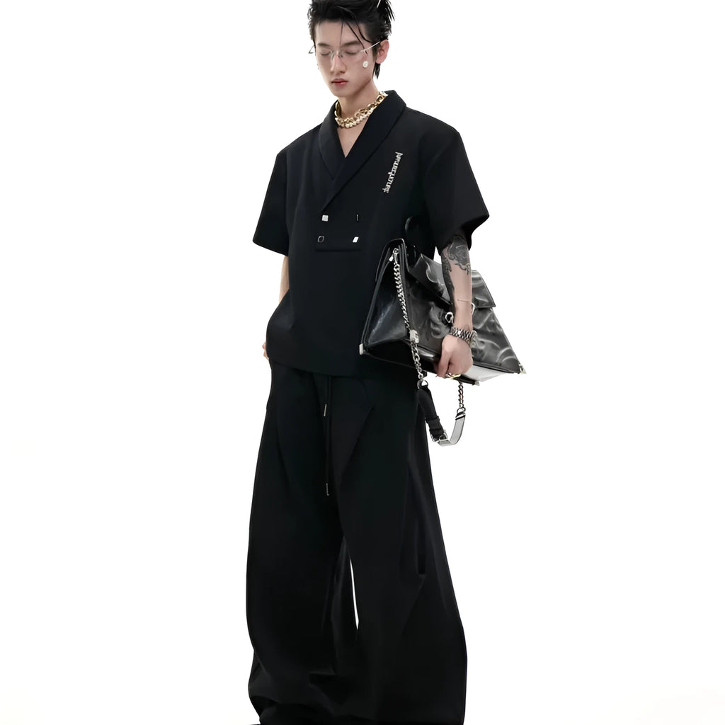 Men's dark grey cotton sports suit with V-neck short-sleeve jacket, padded shoulders, metal embellishments, and matching shorts.