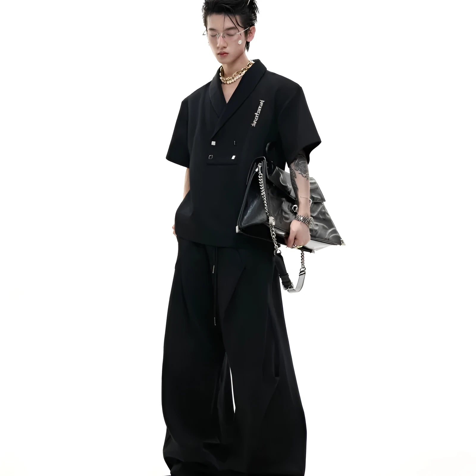 Men's dark grey cotton sports suit with V-neck short-sleeve jacket, padded shoulders, metal embellishments, and matching shorts.
