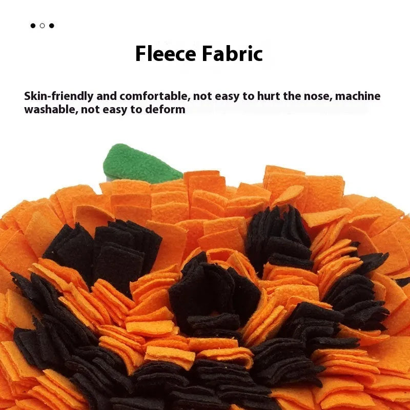 Orange pumpkin-shaped fleece pet slow feeder mat for dogs and cats on a floor.