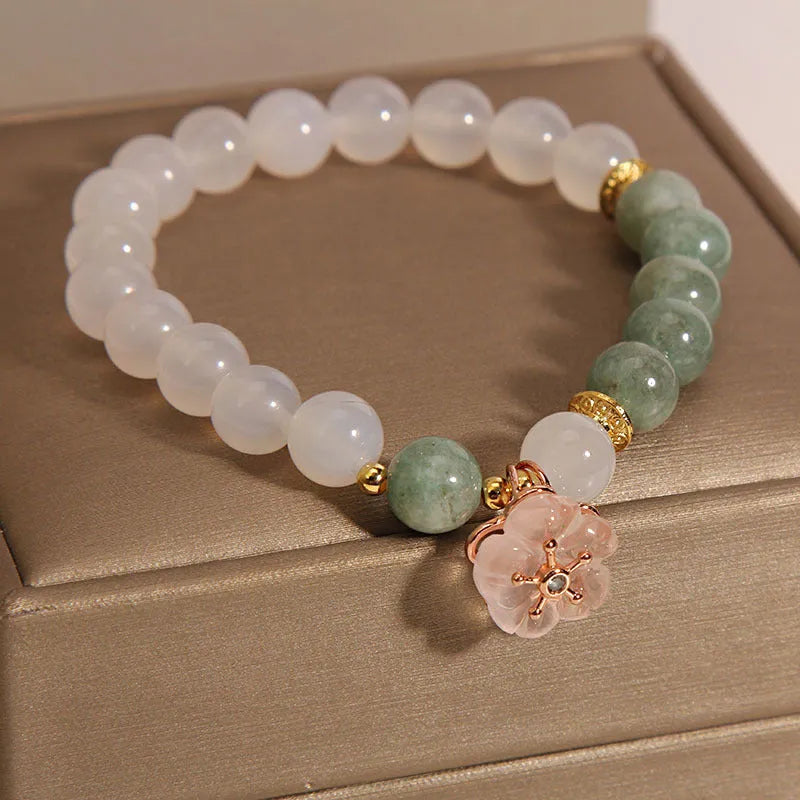 White agate jade flower bracelet with pink accent stones on wrist