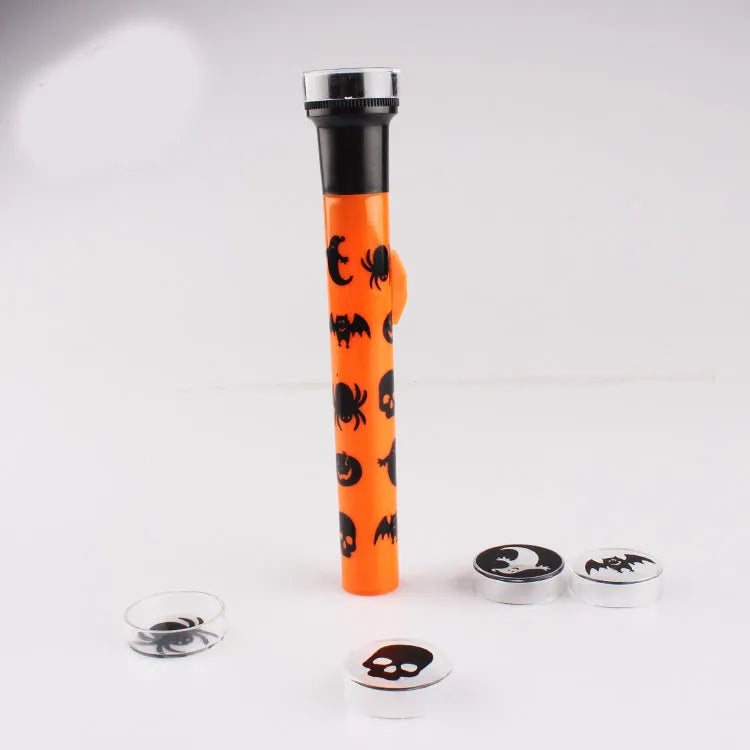 Orange metal pumpkin skull flashlight projection lamp on a plain background