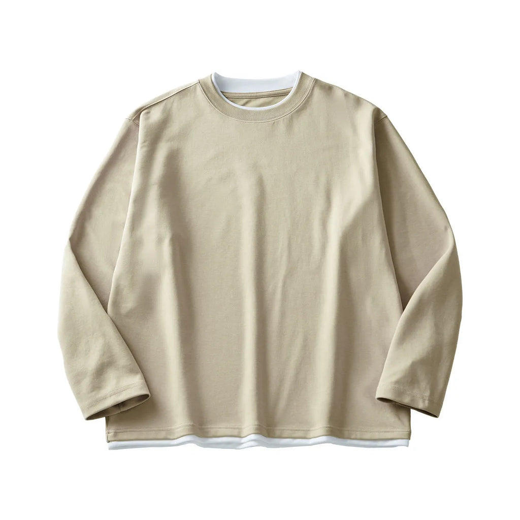 Man wearing a loose fit long-sleeved round neck t-shirt in a solid colour