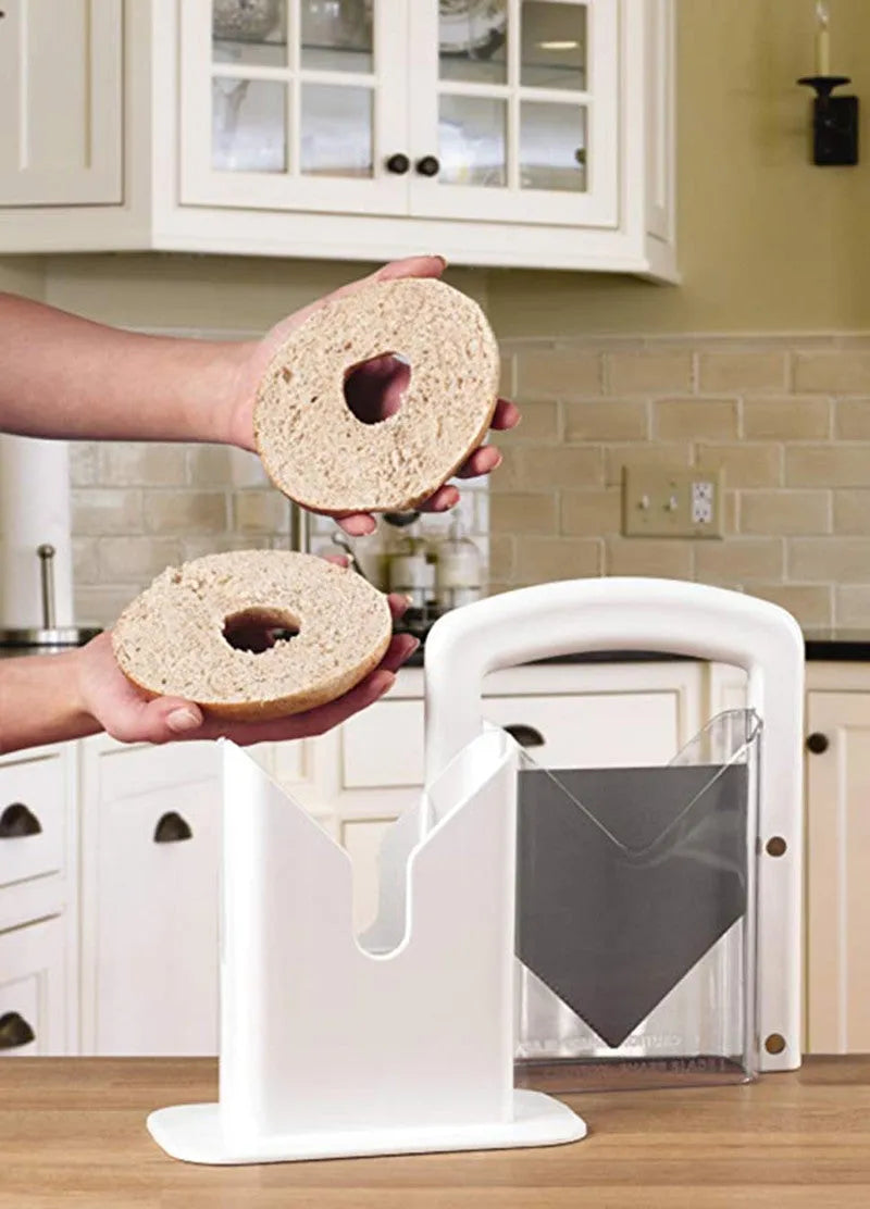 White plastic bagel guillotine slicer with clear acrylic safety shields and stainless steel serrated blade