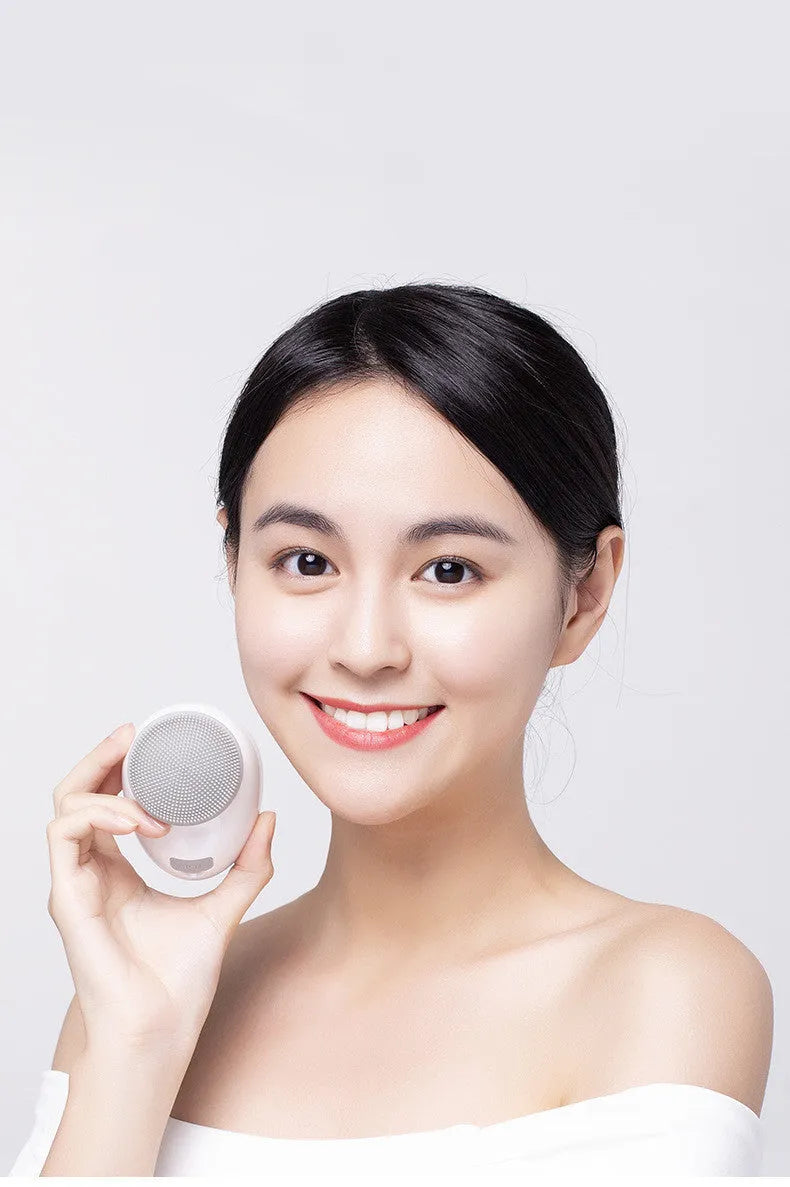 White multifunction USB charging facial cleansing massager with hot egg design, silicone brush head, and 5 vibration modes on a white background