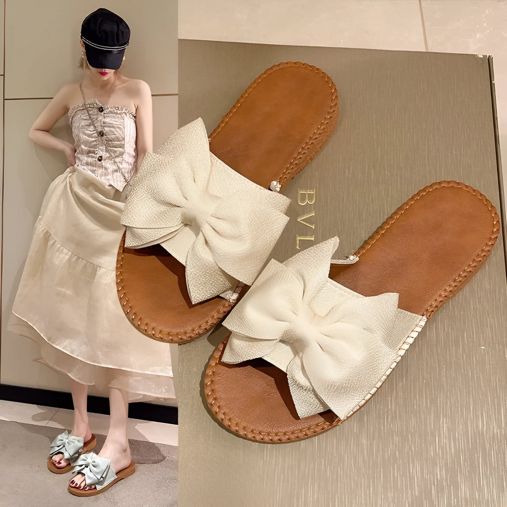Women's slip-on suede sandals with bow detail in beige, light green, and pink colour options
