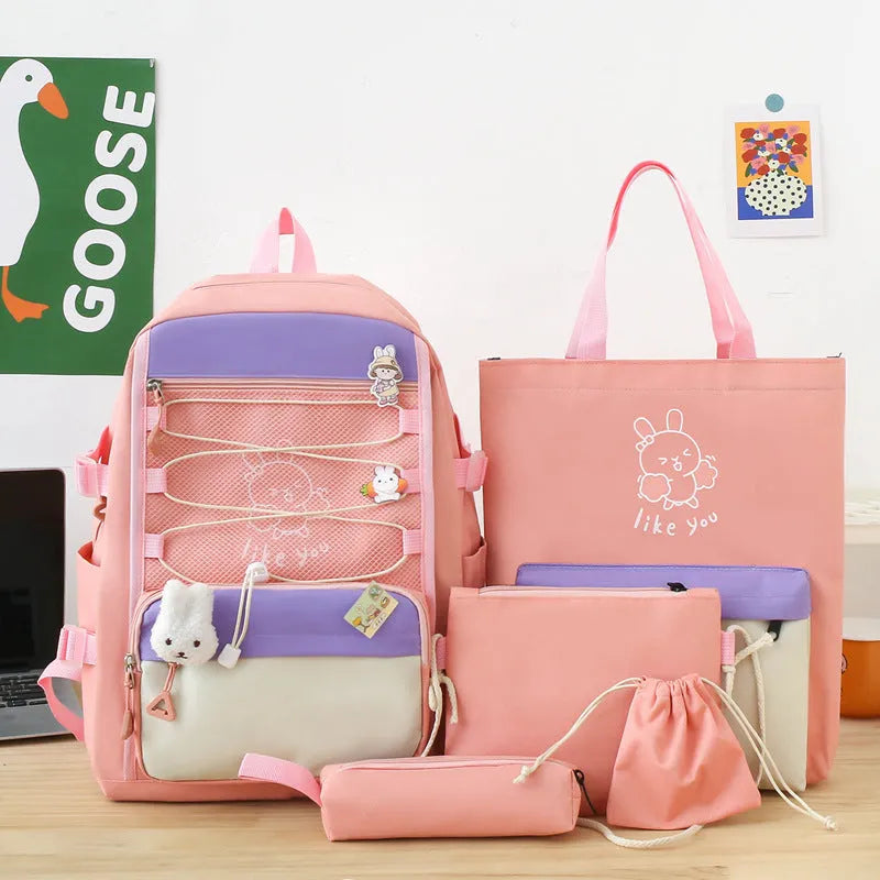 Set of four nylon student backpacks in pink, black, purple, and blue colours with curved shoulder straps