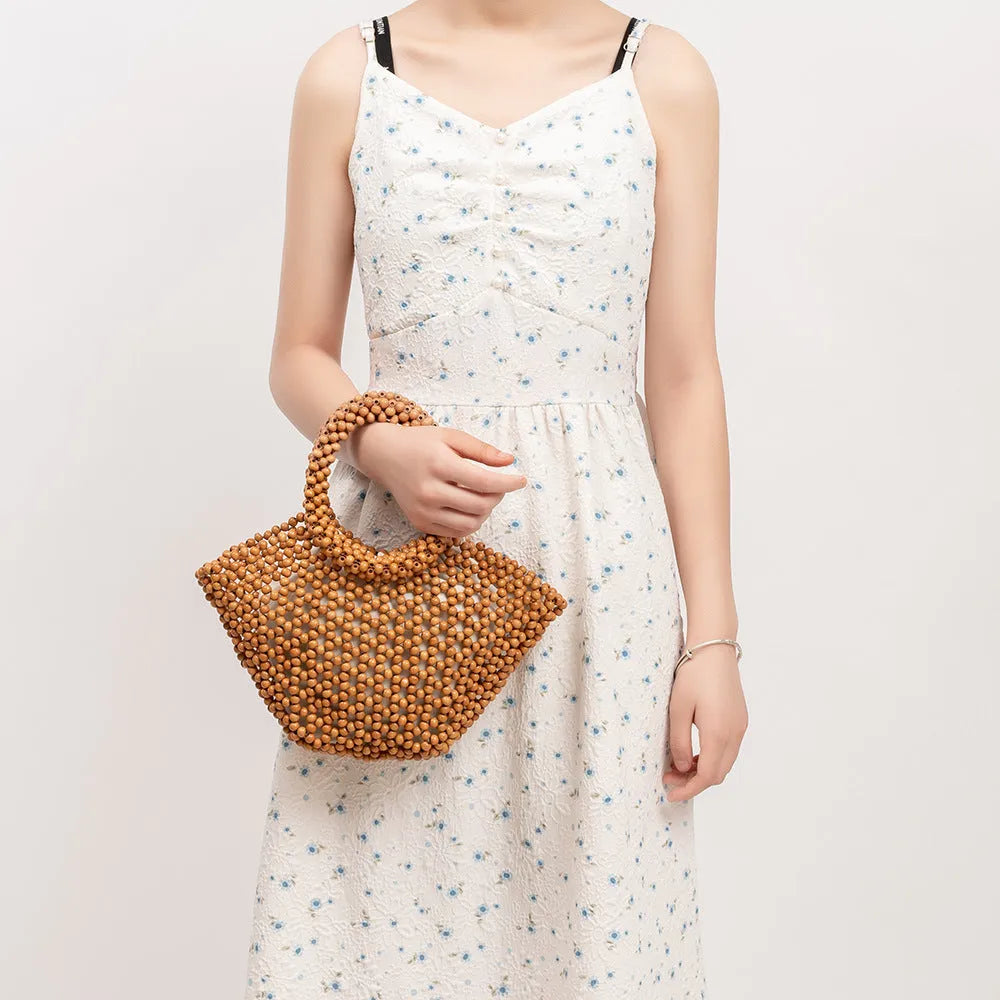 Hand-woven dumpling-shaped maple beach handbag with wooden bead decoration in milky white colour