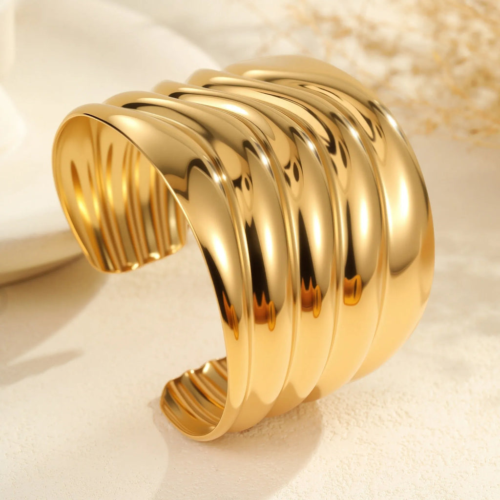 Women's wide geometric wave bracelet with gold plating and niche opening detail on wrist