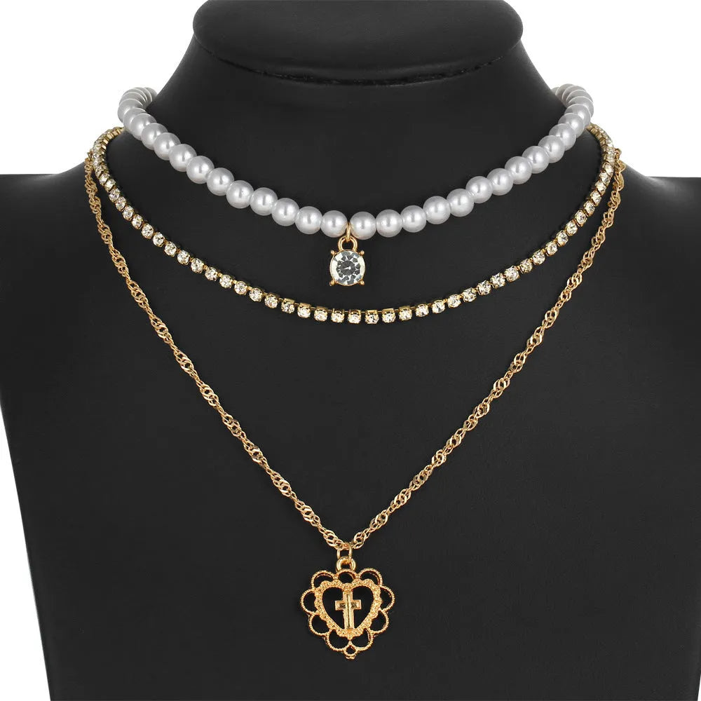 Gold multi-layer rhinestone and imitation pearl necklace on a white background