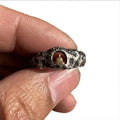 Hand-forged copper Buddha ring with grotto rock texture, shown on a size 8 finger.
