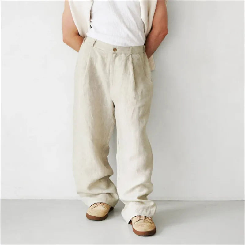 Man wearing loose grey linen high waist jogger pants with elasticated waistband.