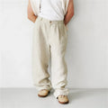 Man wearing loose grey linen high waist jogger pants with elasticated waistband.