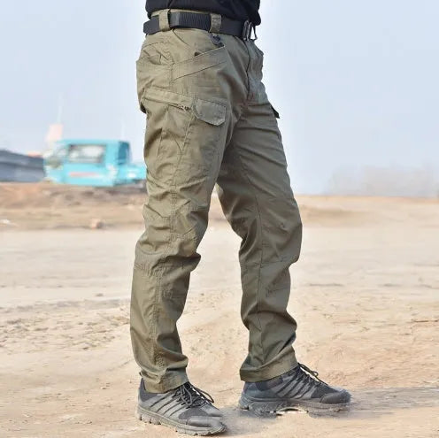 Outdoor multi-legged tactical pants in khaki cotton blend with multiple pockets on legs, shown against natural background