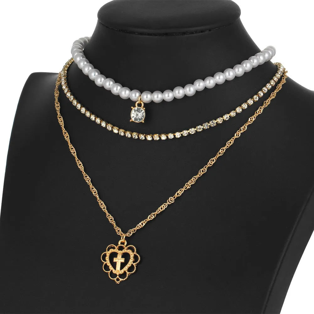 Gold multi-layer rhinestone and imitation pearl necklace on a white background