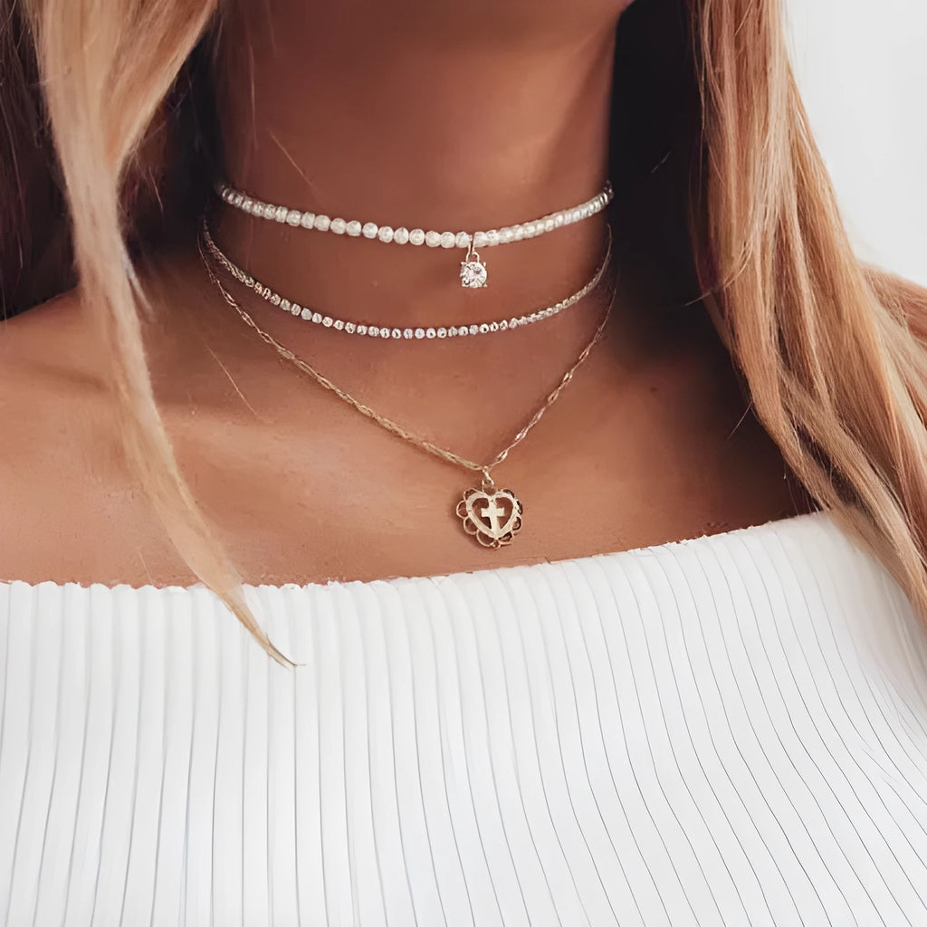 Gold multi-layer rhinestone and imitation pearl necklace on a white background
