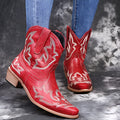 Women's blue embroidered cowboy boots with a wedge heel and pointed toe on a white background.