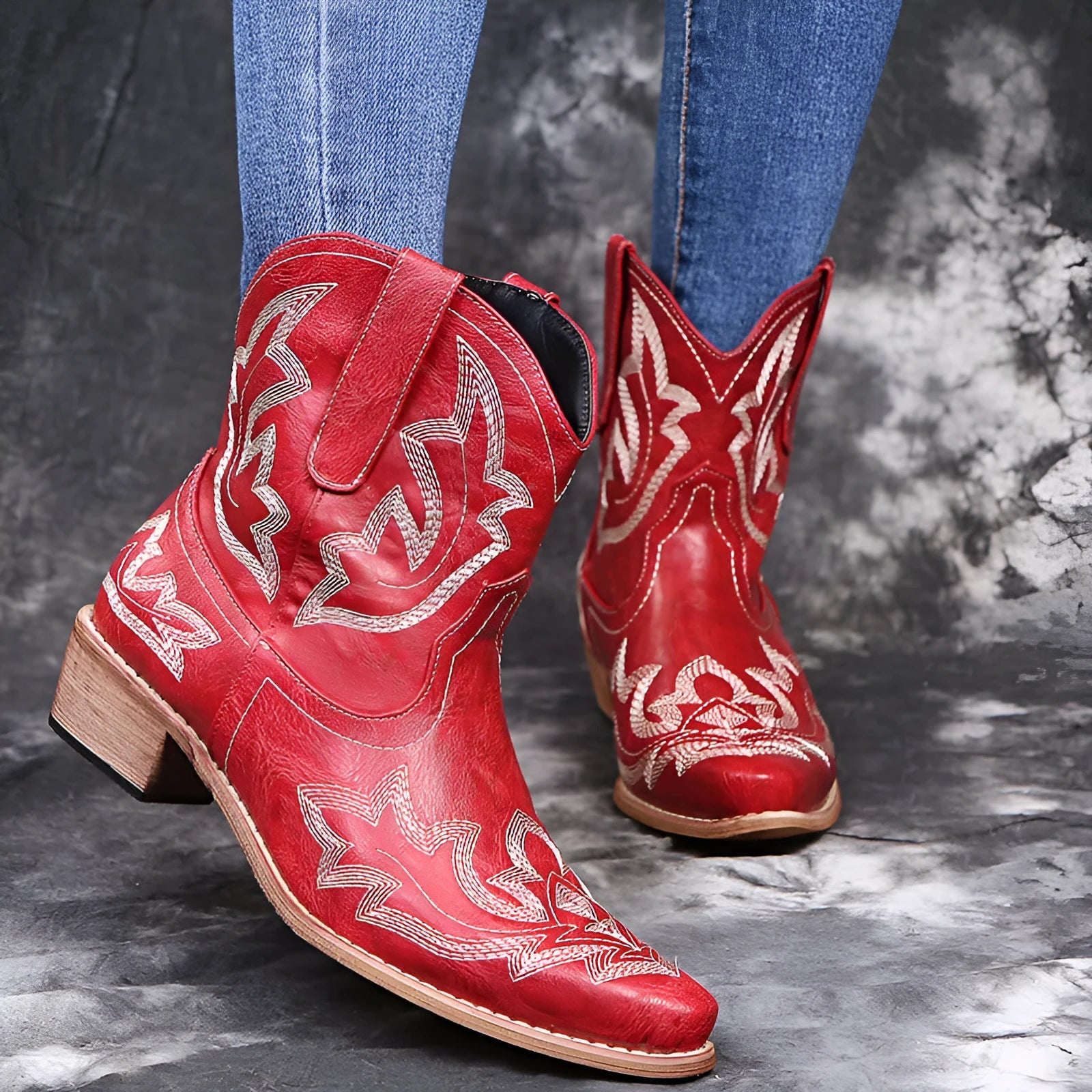 Women's blue embroidered cowboy boots with a wedge heel and pointed toe on a white background.