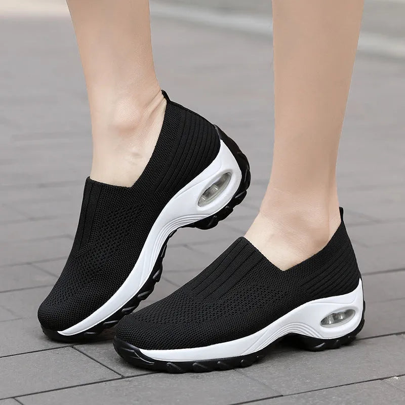 Women's mesh sports shoes in black, side view, showing breathable upper, thick bottom sole, and slip-on design