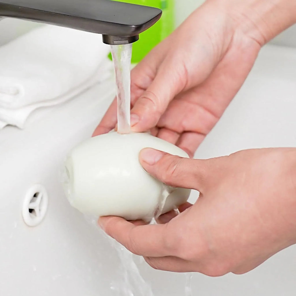Green washable reusable gel lint roller ball for pet hair removal on fabric.