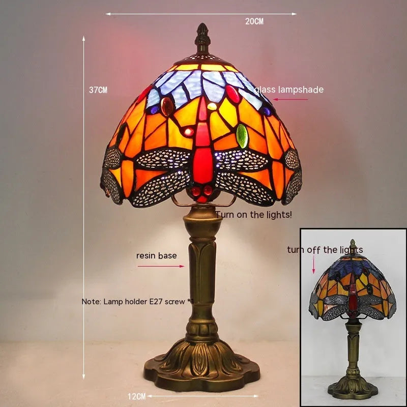Tiffany-style stone table lamp with blue dragonfly design on a wooden surface.