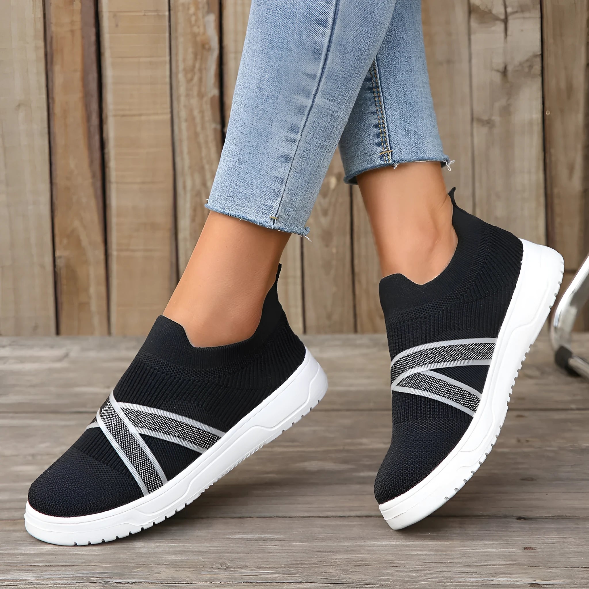 Black women's low-top flyknit mesh flat shoes with round toe and tassel detail on a rubber sole.
