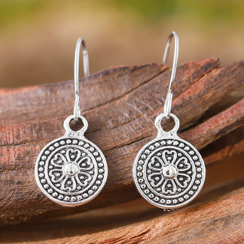 A pair of geometric Bohemian-style retro earrings with a distressed round ethnic print on zinc alloy.