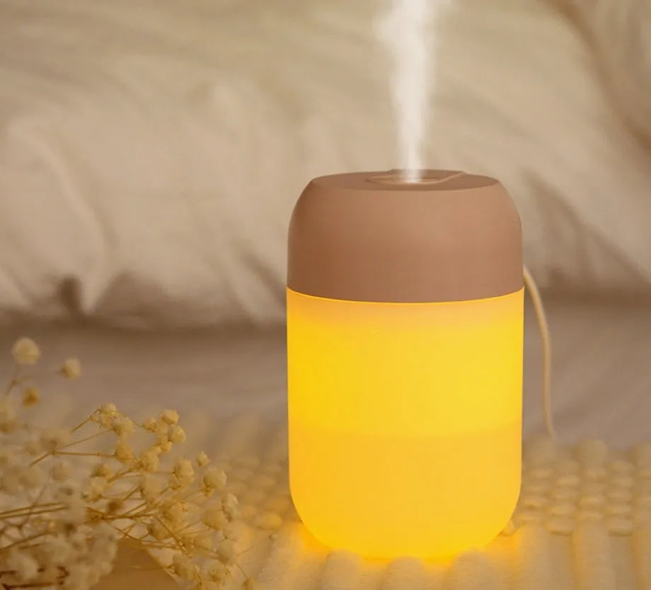 Small white cylindrical USB-powered personal humidifier on a desk.