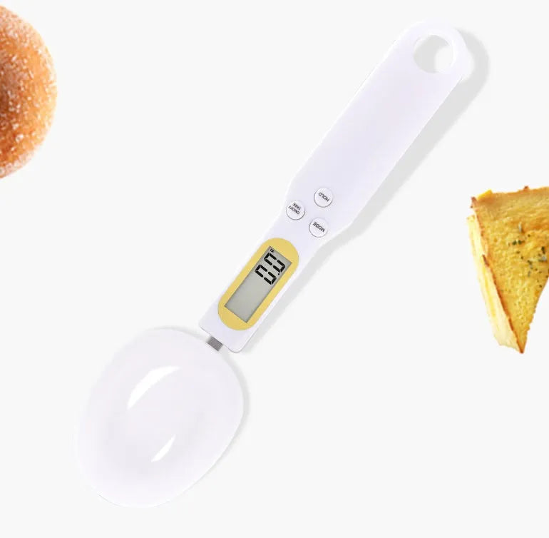 Black electronic measuring spoon scale on a kitchen counter showing digital display.