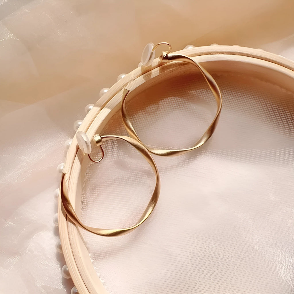 Rotatable circle mosquito coil ear clip in matte gold with rubber pads for women
