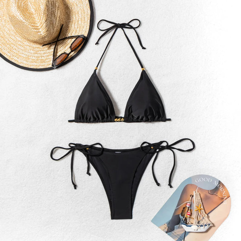 Black women's bikini swimsuit with split leg design and decorative metal bead.