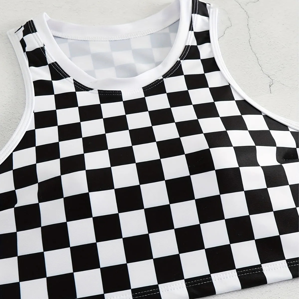 Women's black and white checkerboard racing one-piece swimsuit with backless design and suspender straps