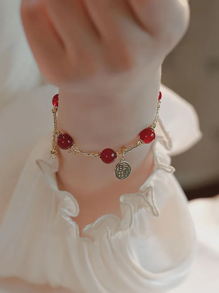 Red agate and alloy double-layer women's bracelet with Hongma blessing card charm on an adjustable fastening.