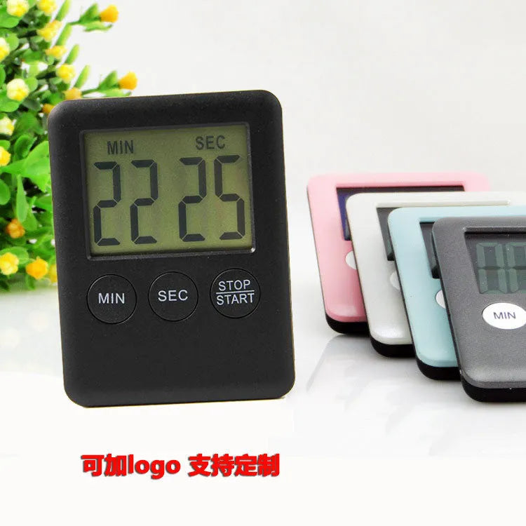 Black and white digital kitchen timer with magnetic back and LED display showing countdown time
