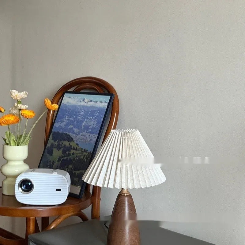 Nordic retro ceramic table lamp with pleated floral shade and remote control on a wooden bedside table.