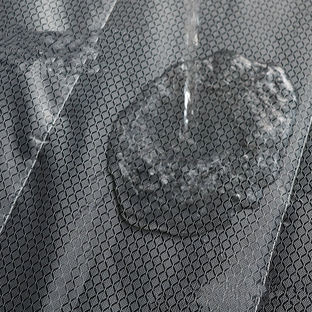 Magnetic strip cotton door curtain in a grey diamond lattice pattern, shown hanging over a doorway.