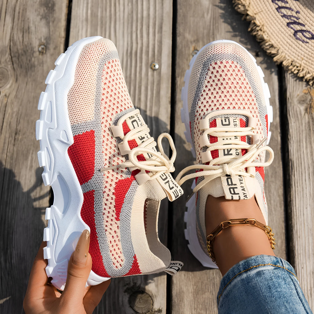 Women's Flyknit mesh lace-up sneakers in grey and white colour combination on a flat rubber sole.