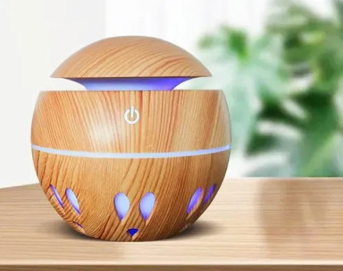 USB aroma diffuser humidifier in light wood grain, 100x100x95mm, 130ml tank, coloured lights on desk