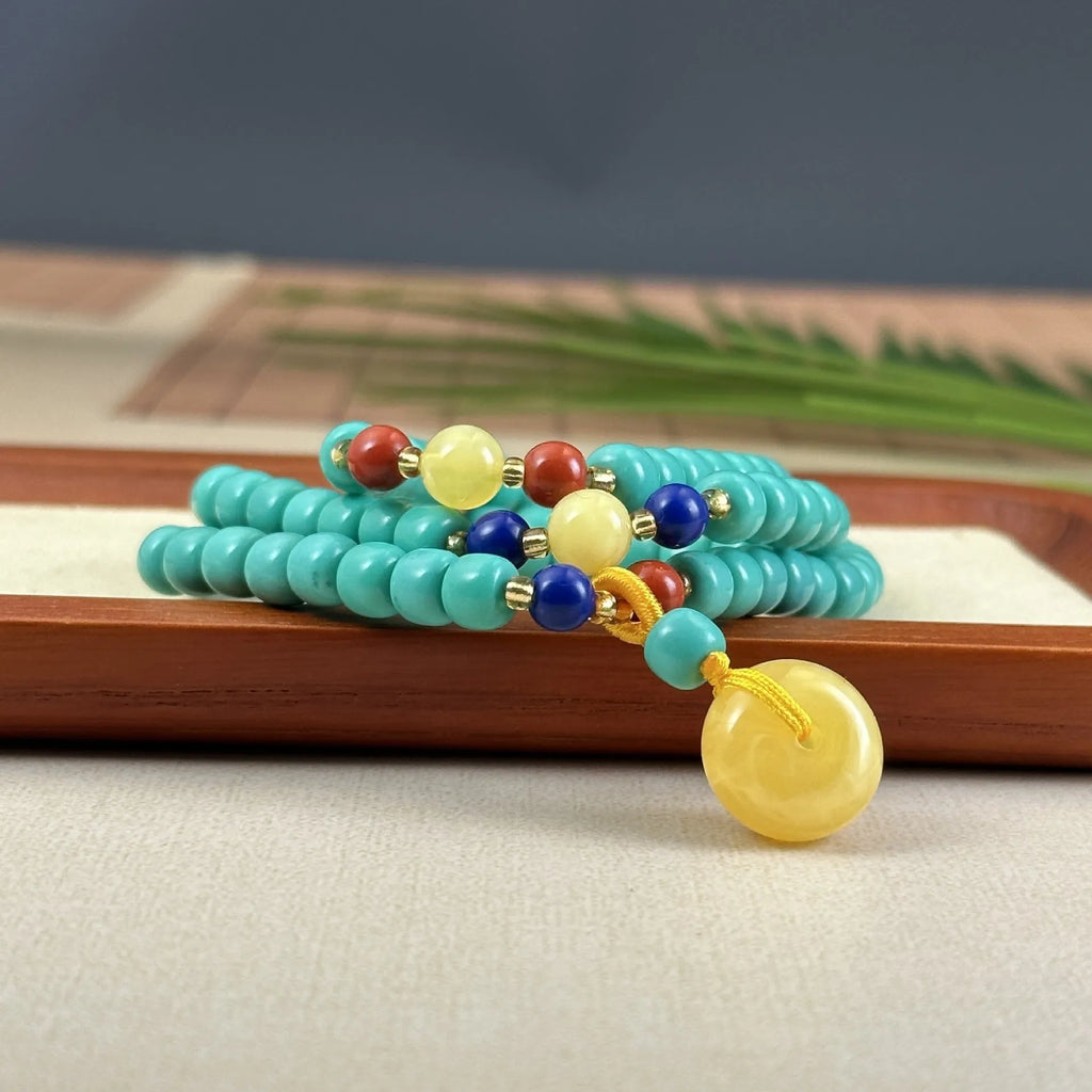 Turquoise ball bead necklace with a hand-woven mesh flower lucky pendant in stone.